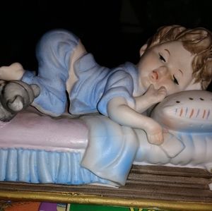 Little boy sleeping in bed statue